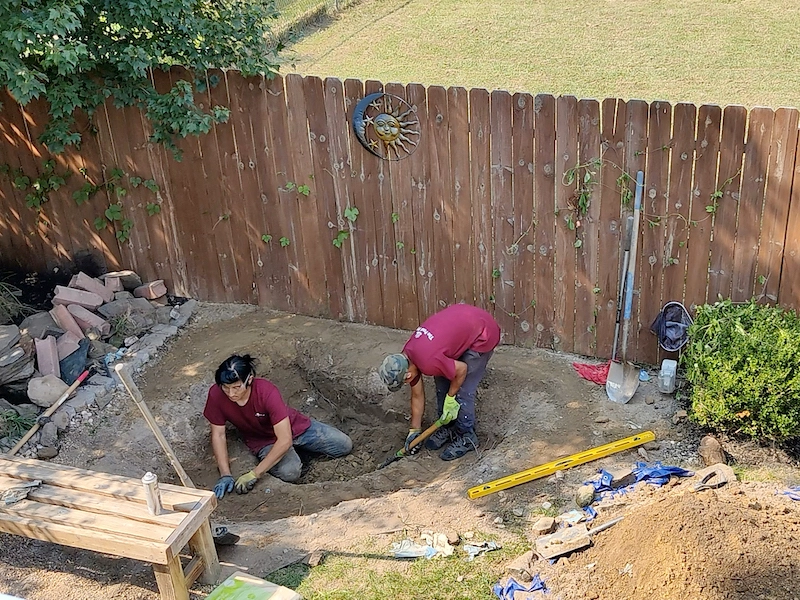 two man crew excavating a hole for the pond