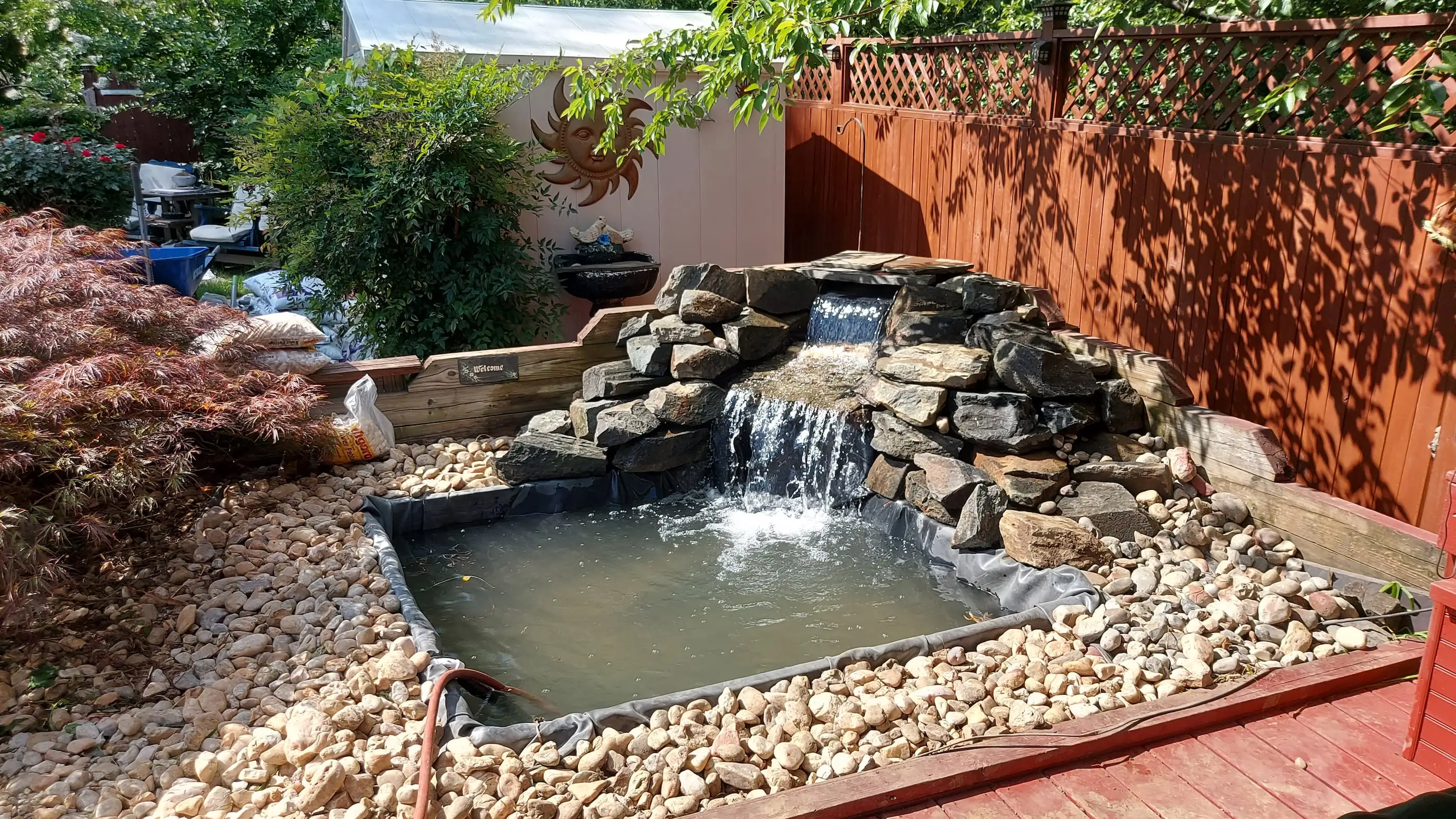 A water feature built in Baltimore MD. Ticondoroga boulders were used to build a small waterfall
						at the corner facing the patio. 