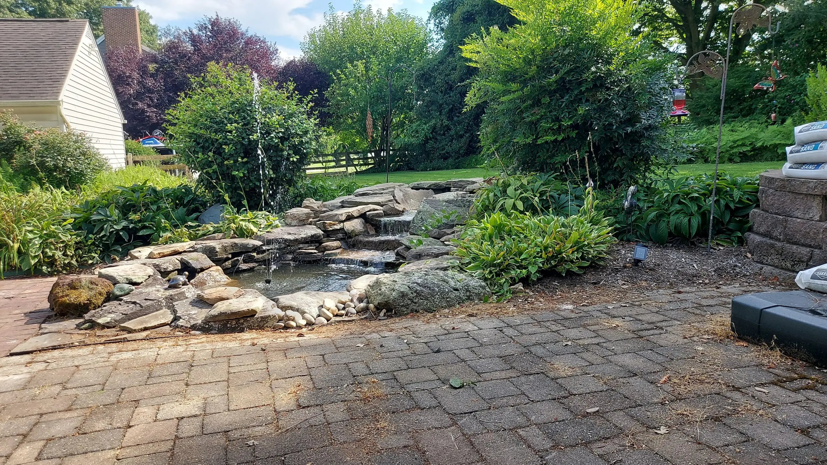 A leaking waterfall rebuilt in River Hill, Maryland. During a rebuild the pondless water fall needs to be disassmbled and rebuilt. The first step of this process is removal of stones and liner. With a partially blank slate,
					the ground is reexcavated to ensure no leaks occur and the water is rebuilt with new liner and underlayment.